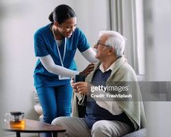 Hình ảnh về Smiling nurse assisting an elderly patient