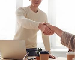 Hình ảnh về Handshake over a computer  symbolizing career opportunity after informatics certification